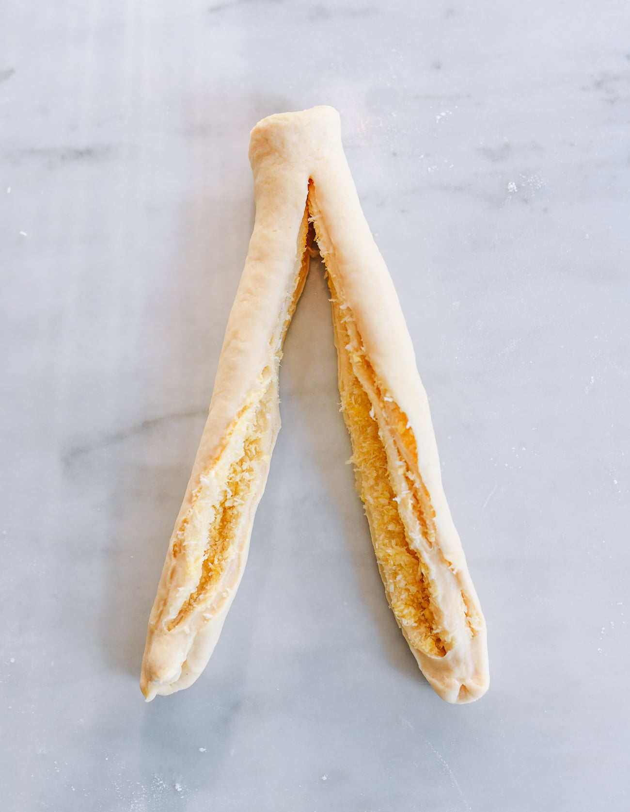 Cutting dough cigar in half lengthwise
