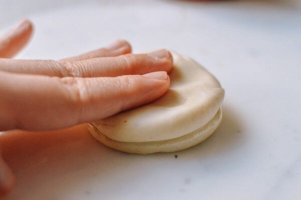 pressing two discs of dough together for mandarin pancakes