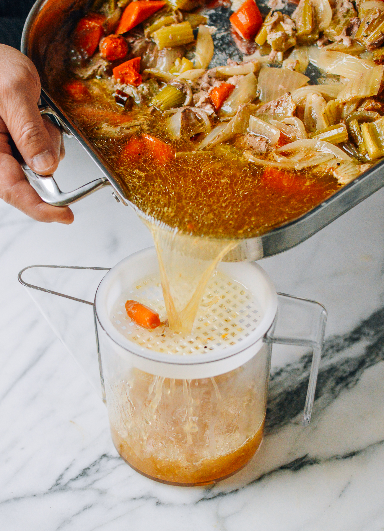 pouring juices from turkey roasting pan into fat separator