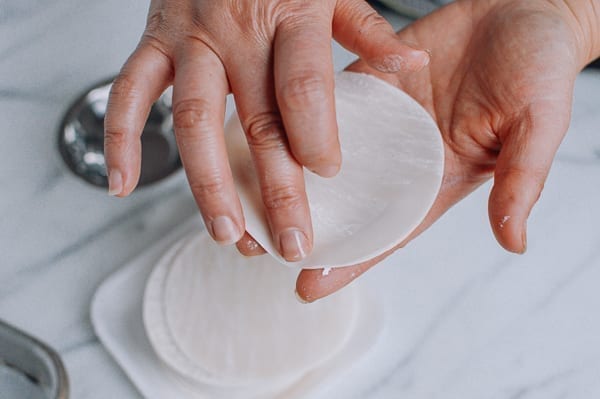 Using a finger to moisten outer edges of dumpling wrapper, jcghk.dfhdjkvfj.cf