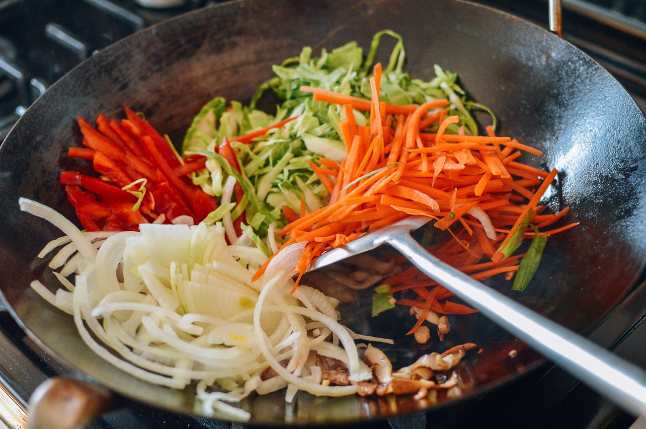 mushrooms, onions, carrots, peppers, and cabbage in wok