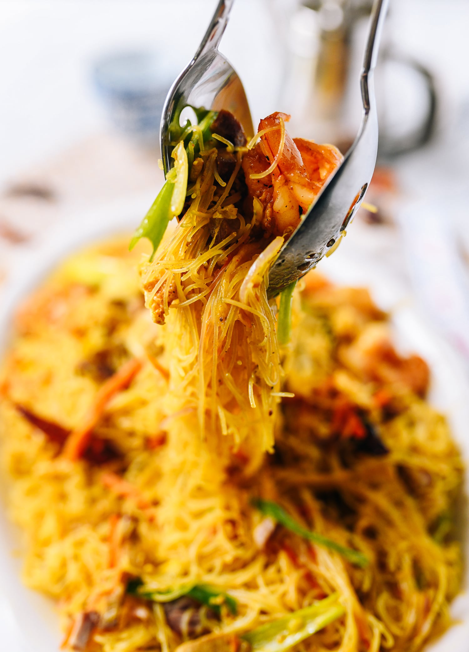 Lifting Singapore noodles off plate with two spoons, jcghk.dfhdjkvfj.cf