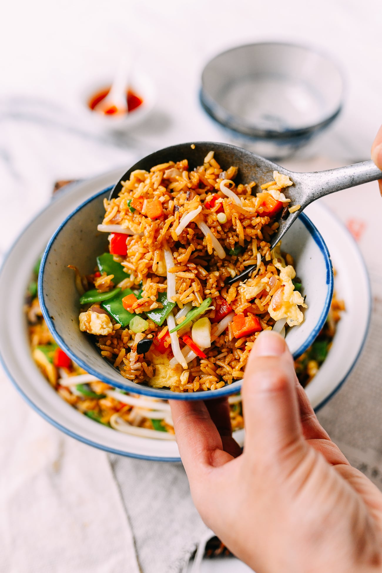 Scooping Vegetable Fried Rice Into Bowl