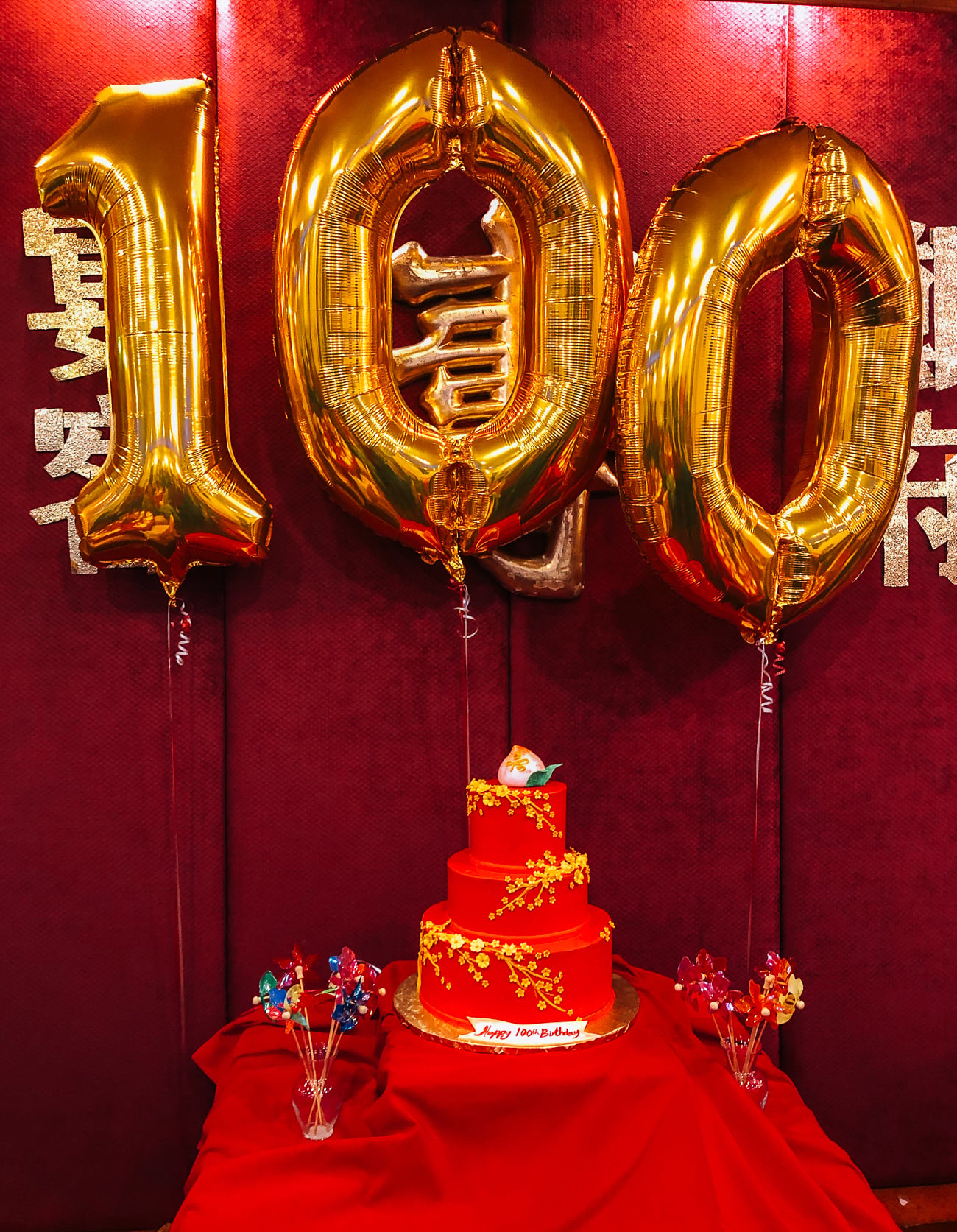 100th birthday cake and balloons