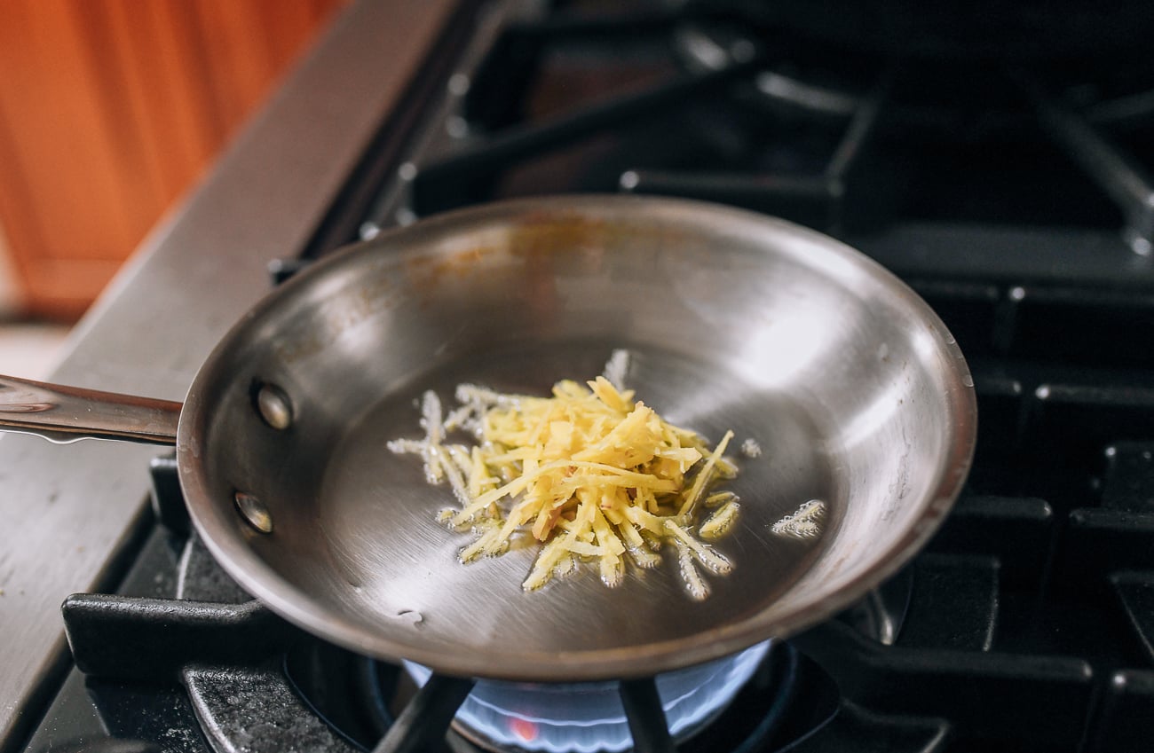 Adding julienned ginger to oil