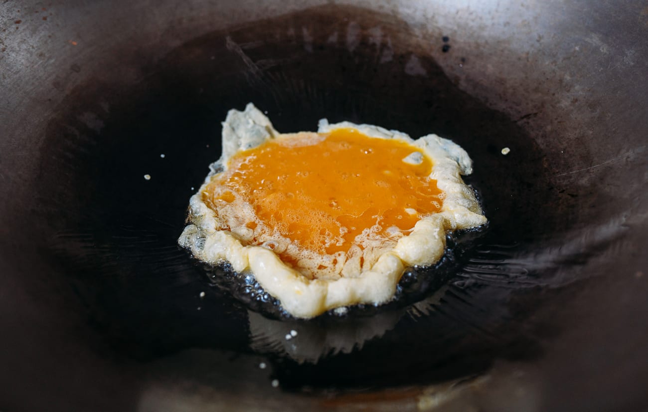 Adding eggs to wok