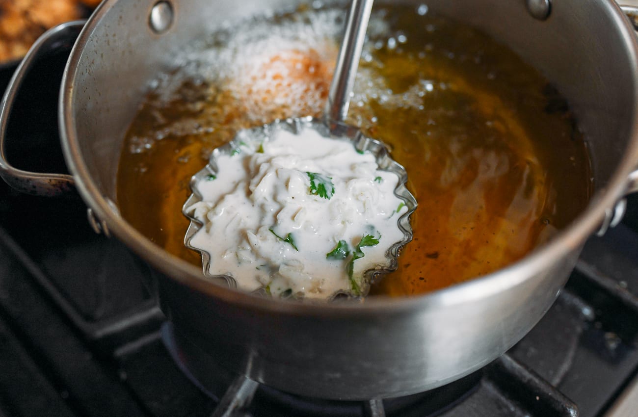 Lowering ladle filled with batter and 