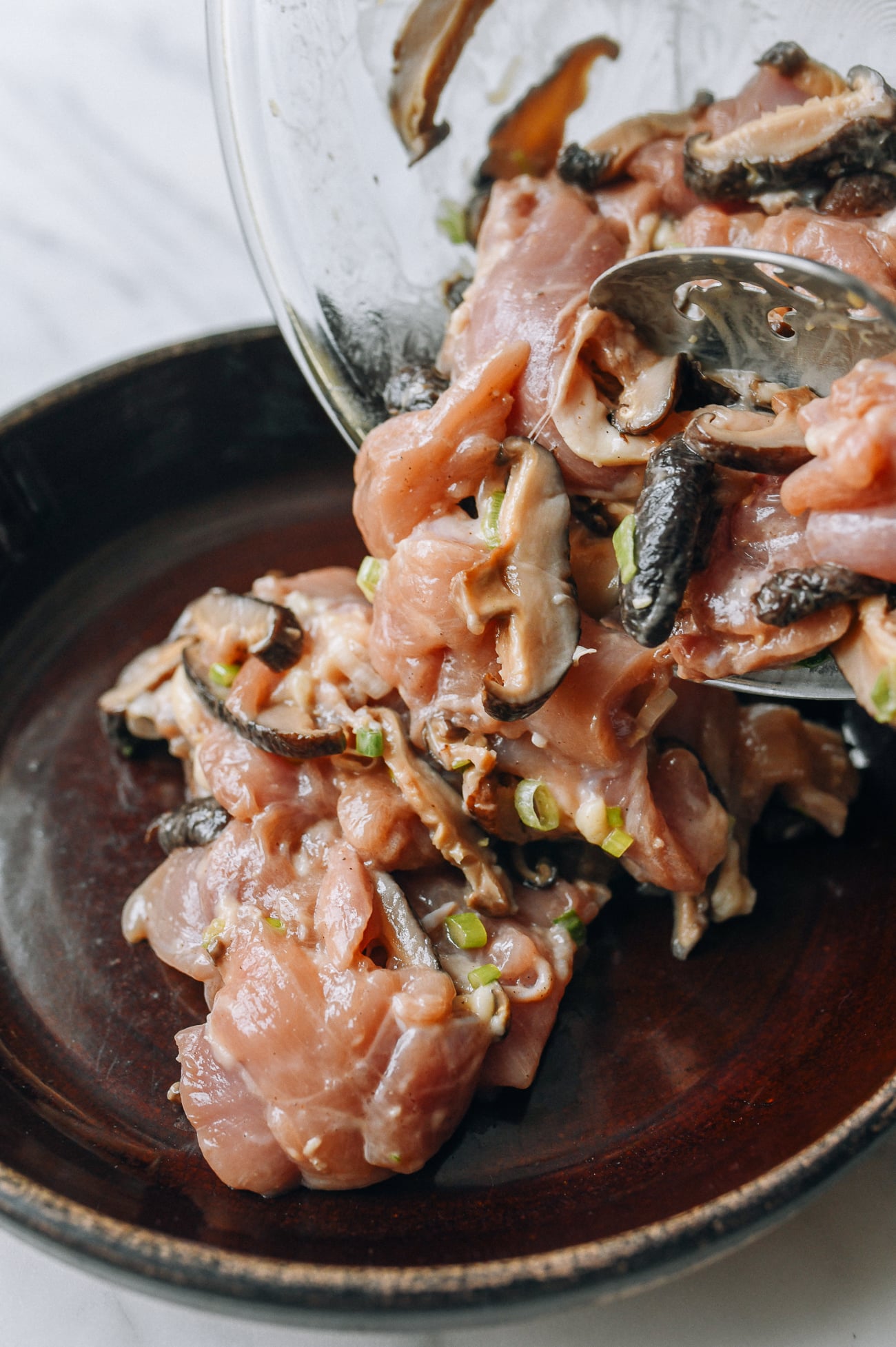 Transferring chicken and mushrooms to heatproof dish