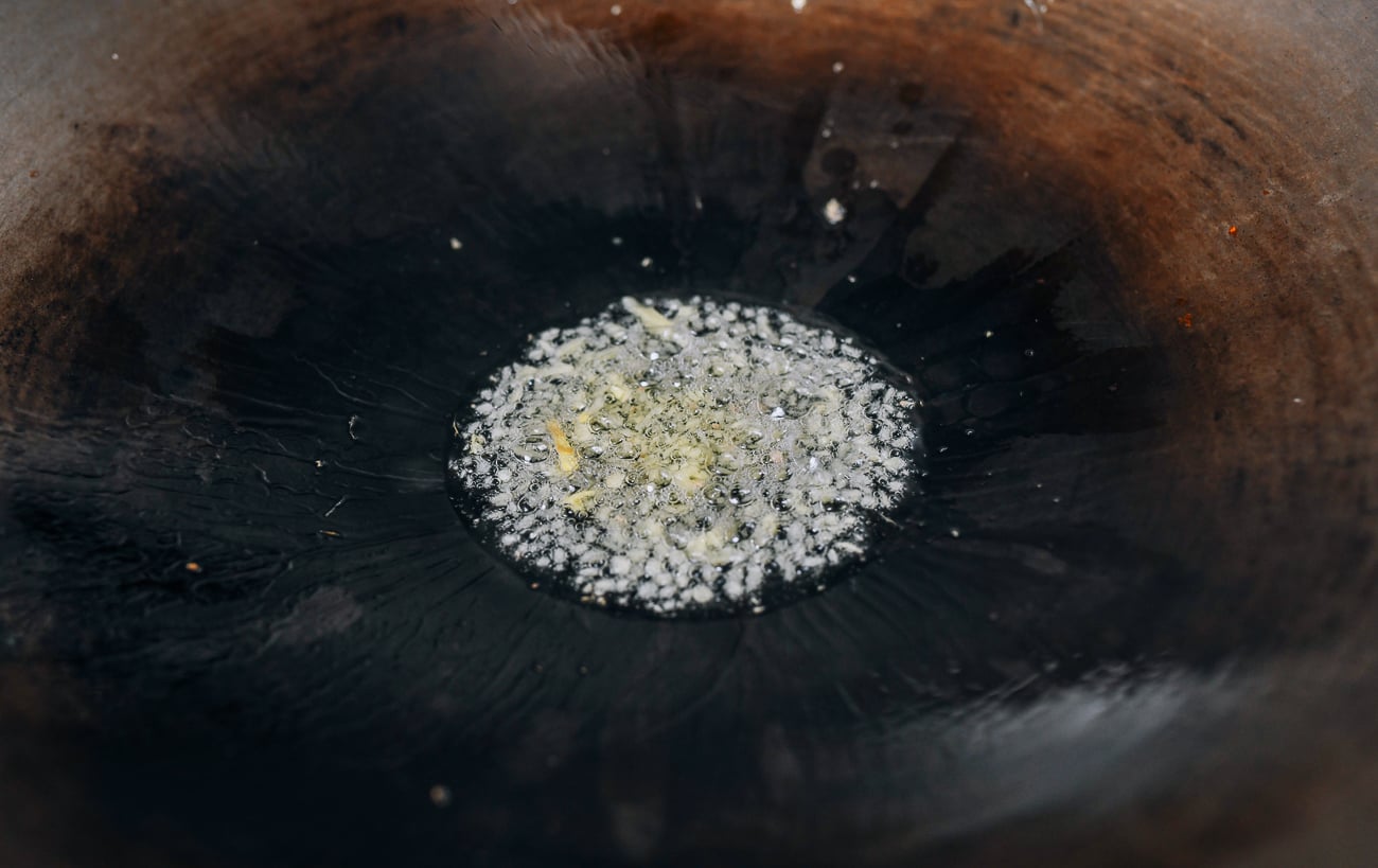 Cooking ginger in oil in wok