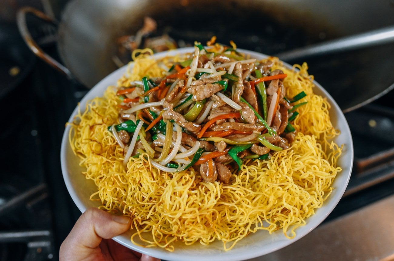 Serving pork stir-fry on top of pan-fried noodles
