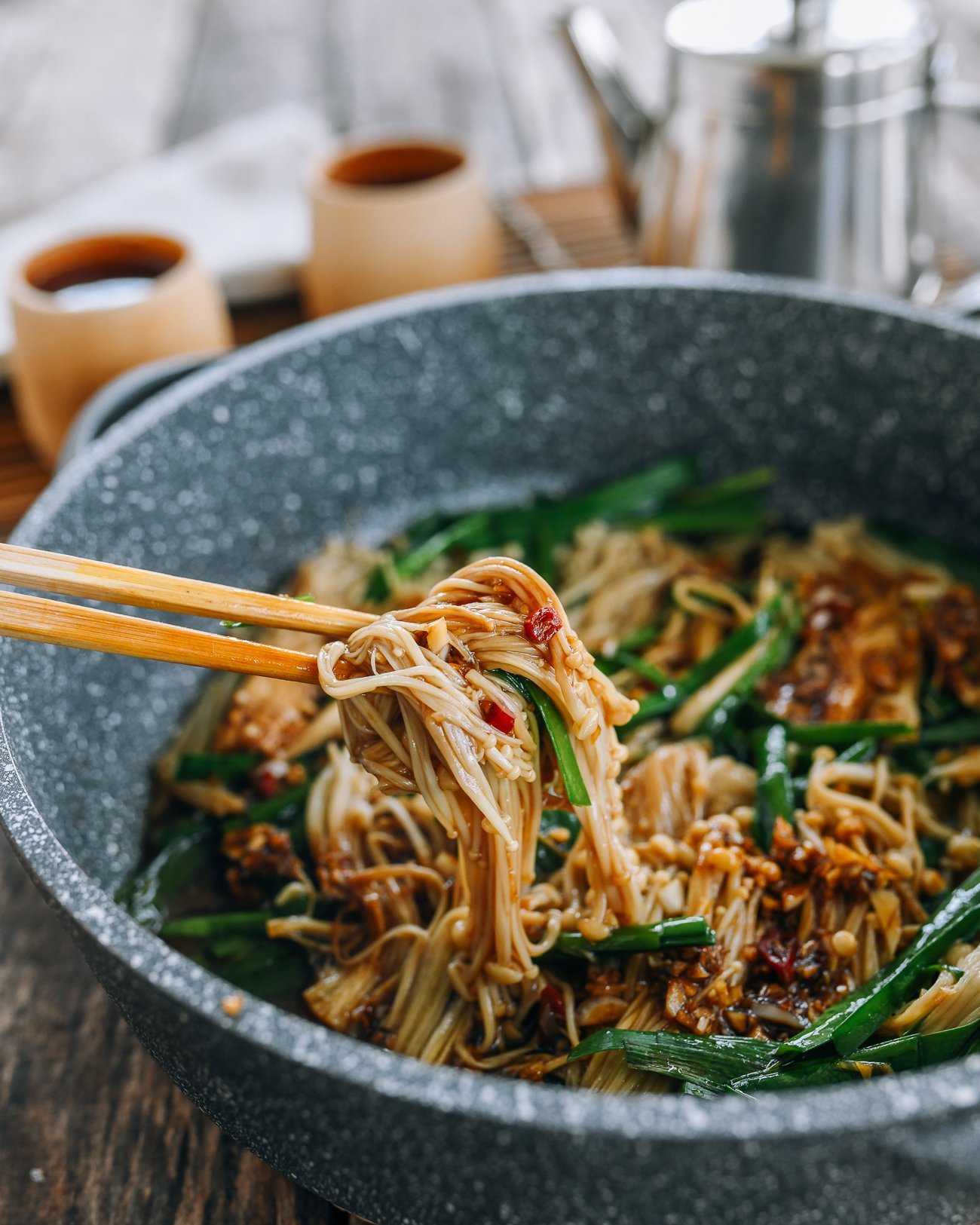 Picking up enoki mushrooms with chopsticks