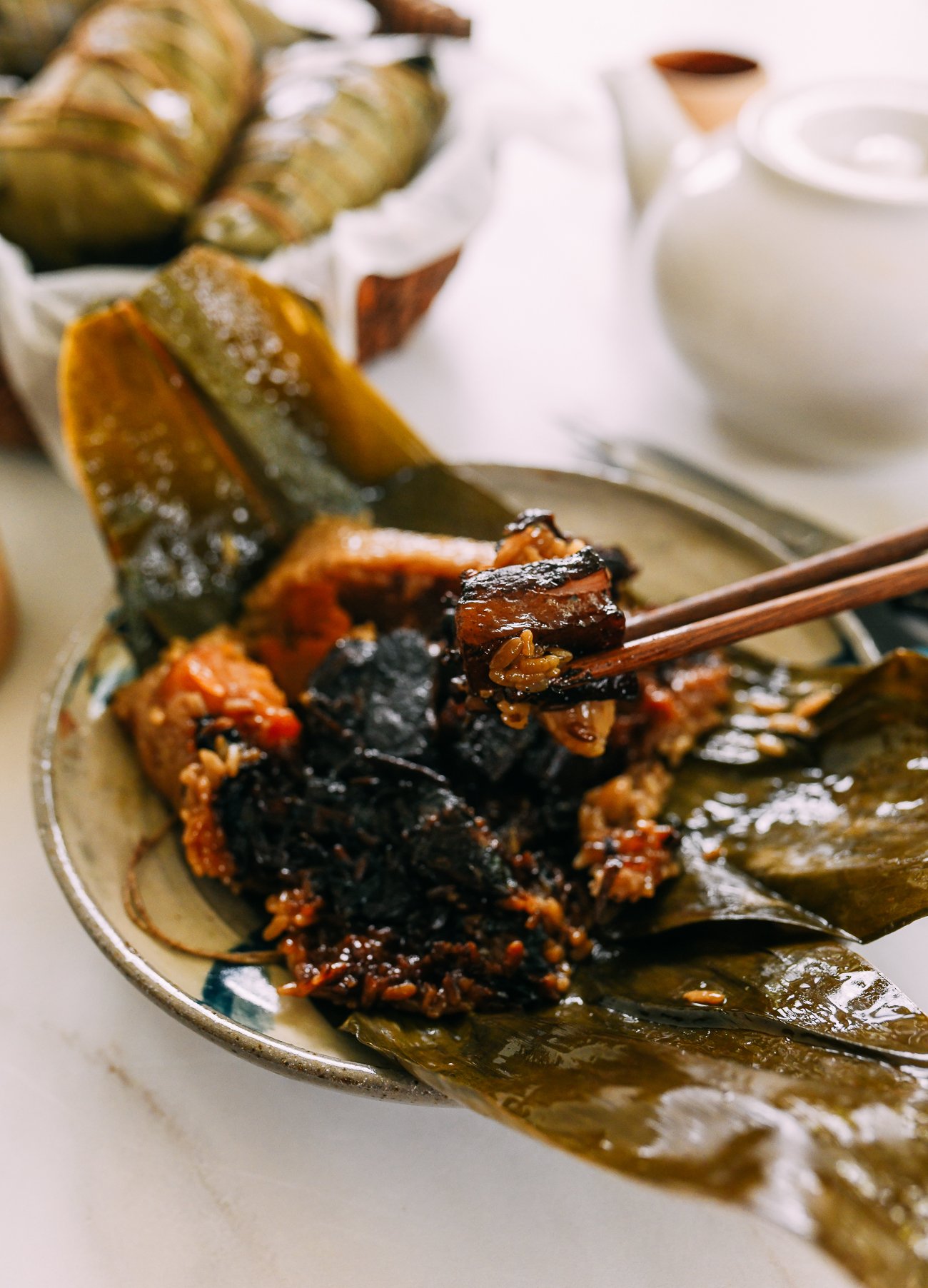 Picking piece of pork belly out of zongzi with chopsticks