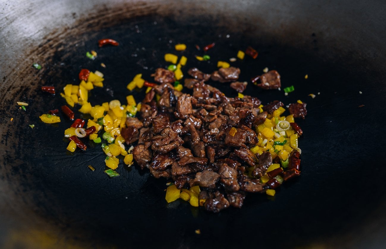 Beef added to vegetables in wok