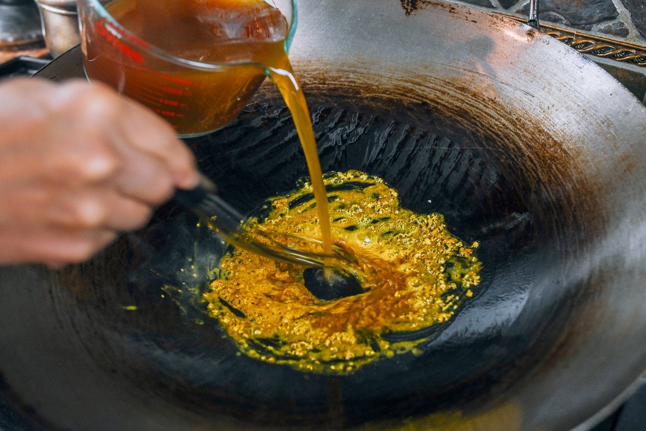 whisking stock into roux in wok