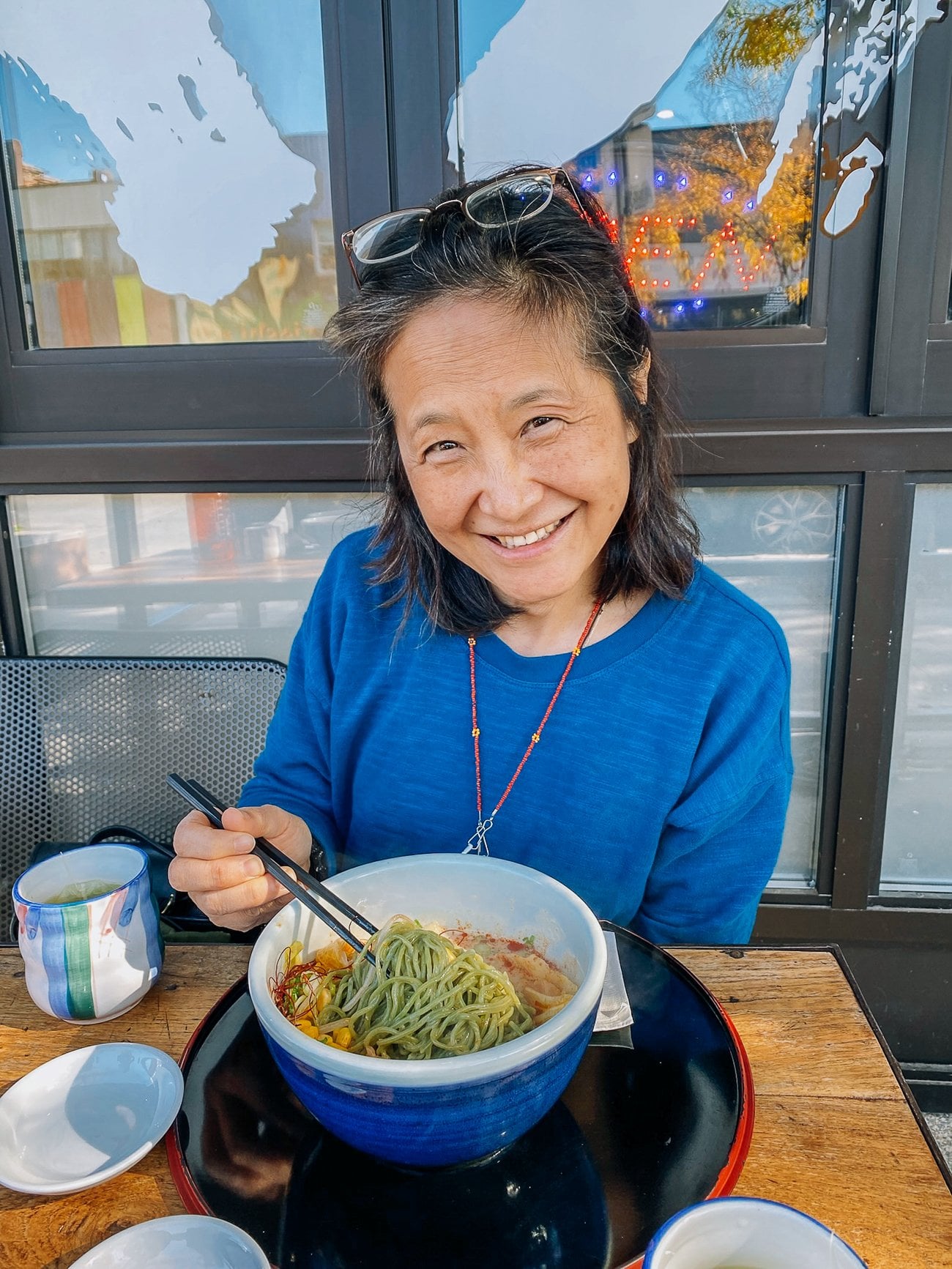 Judy with bowl of ramen kale noodles