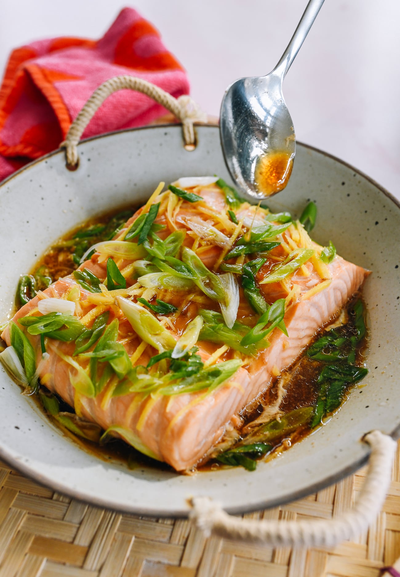 pouring sauce over steamed salmon fillet