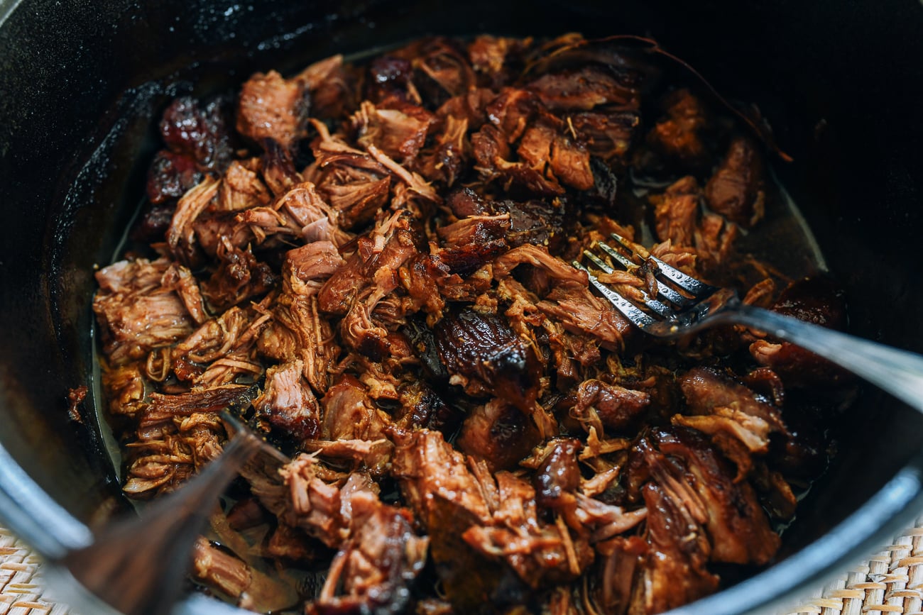 Pulling apart braised pork with forks