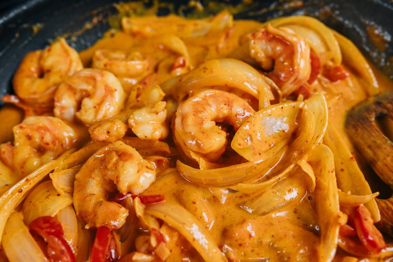 stirring coconut curry shrimp