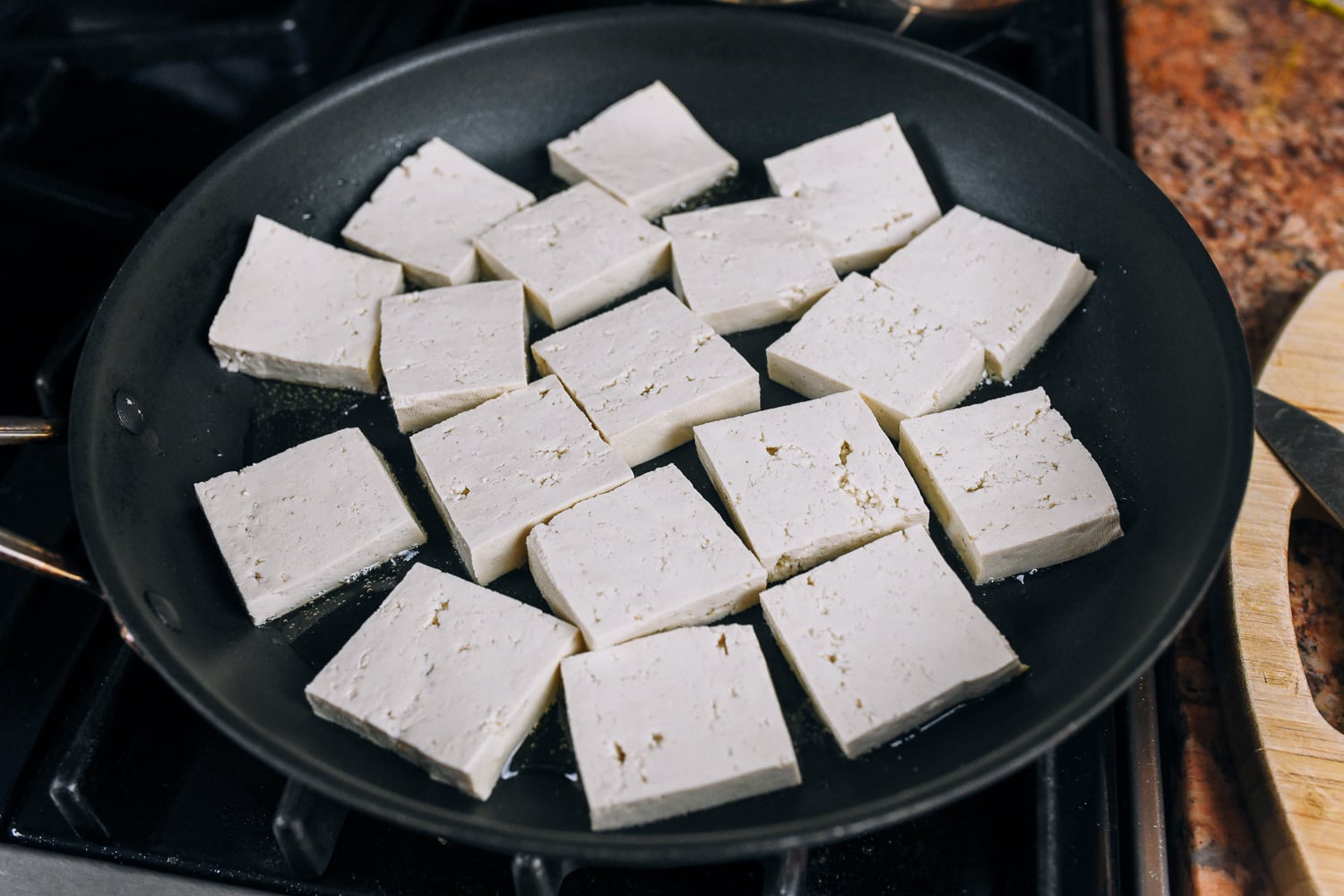 square tofu slices in nonstick pan
