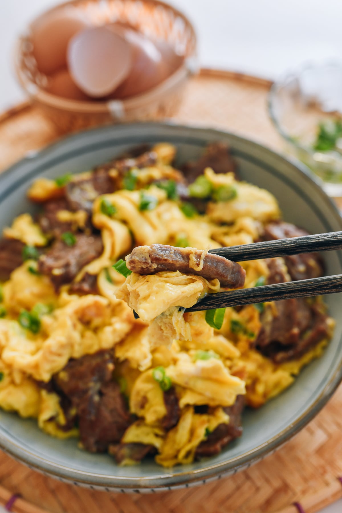 picking up piece of beef and scrambled egg with chopsticks