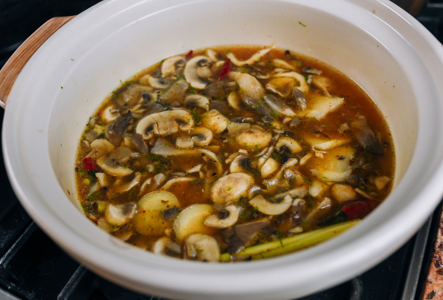 Simmering stock with thai curry paste, aromatics, and mushrooms
