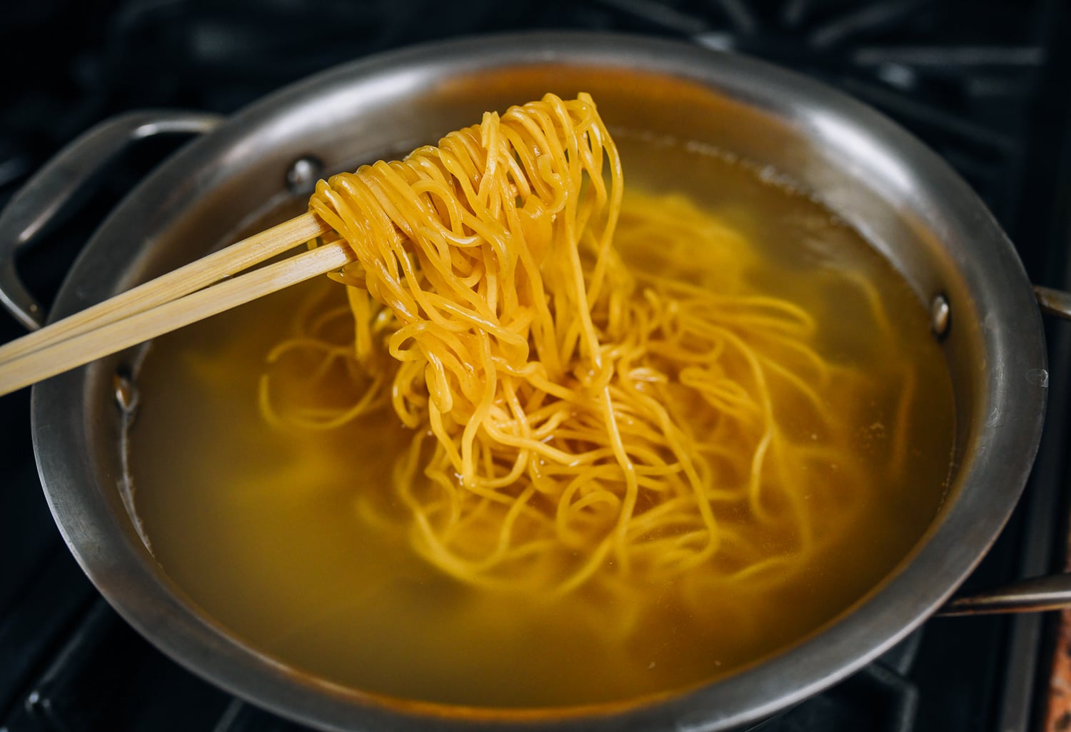 boiling lo mein noodles in medium pot of water