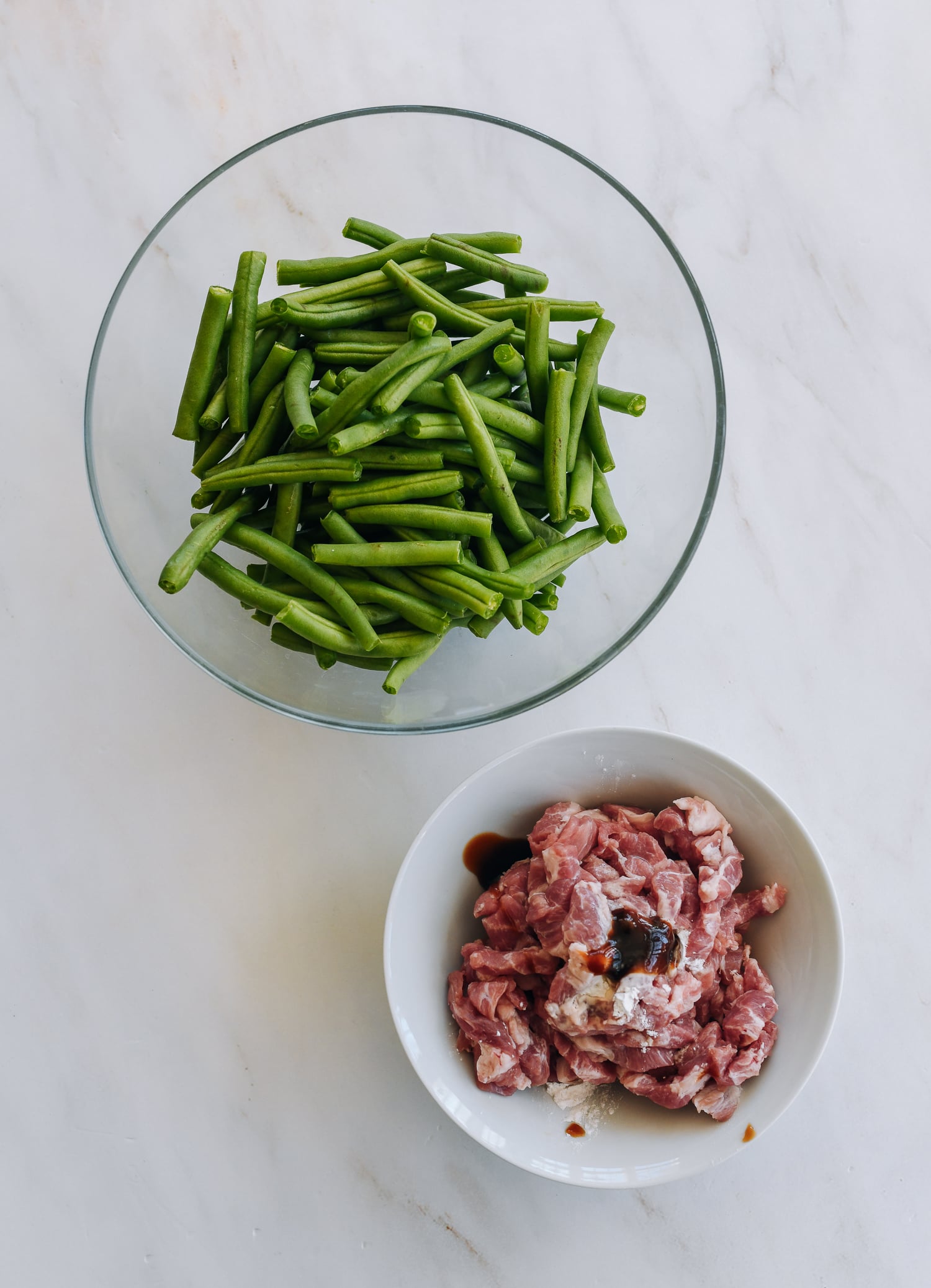 pork with marinade ingredients, and bowl of trimmed green beans
