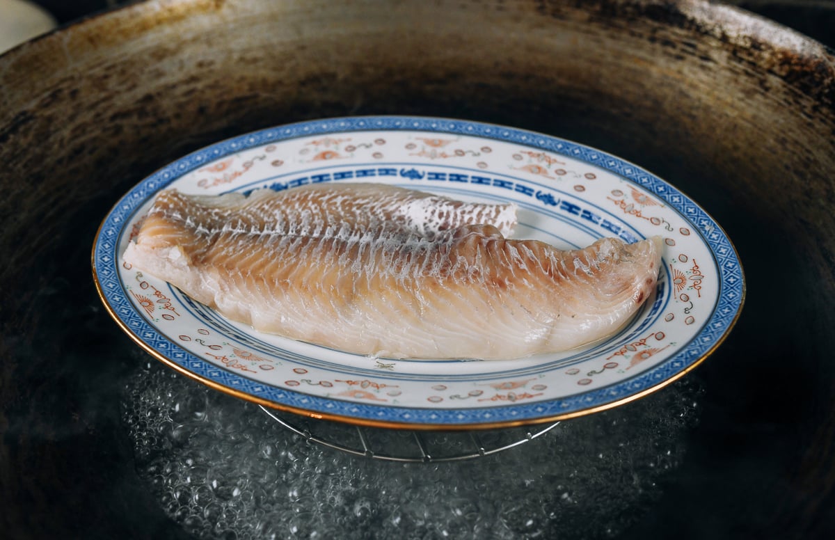 plate of cod in wok for steaming