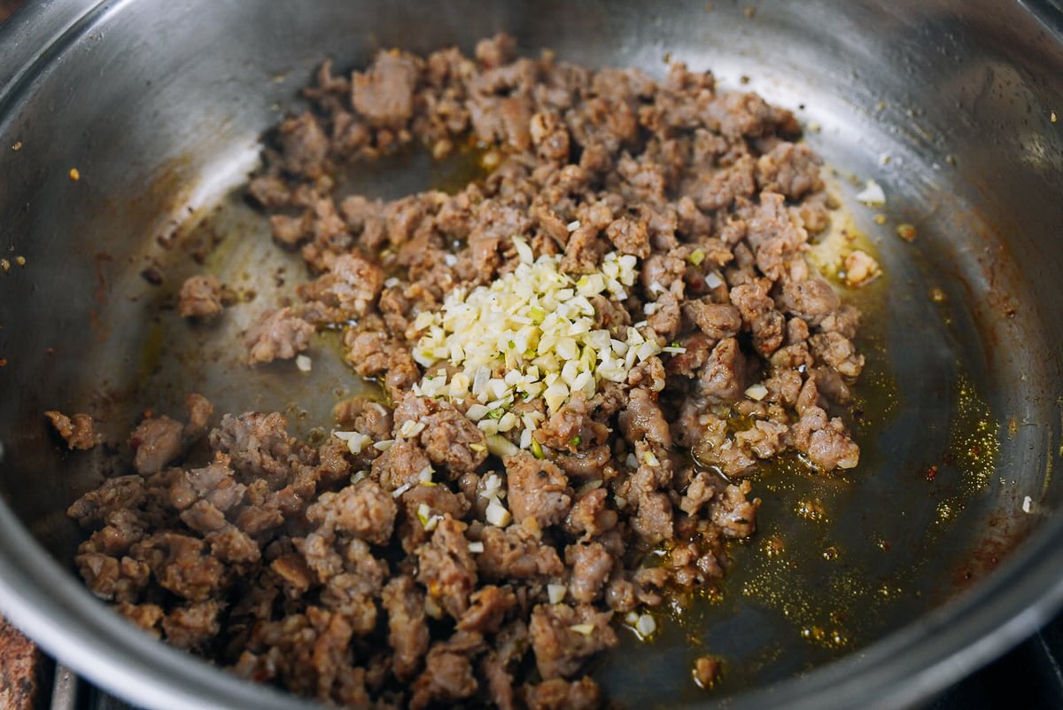 chopped garlic added to sausage in skillet