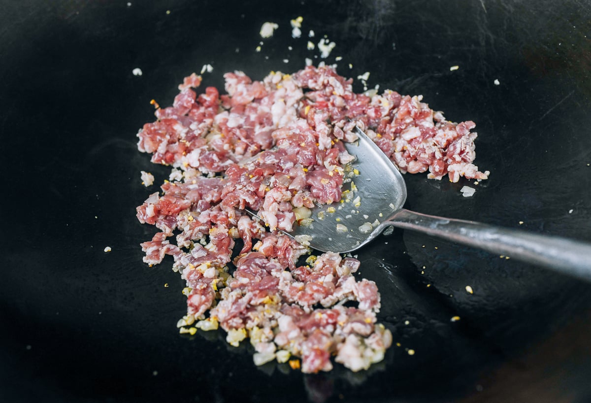 cooking finely chopped pork in wok