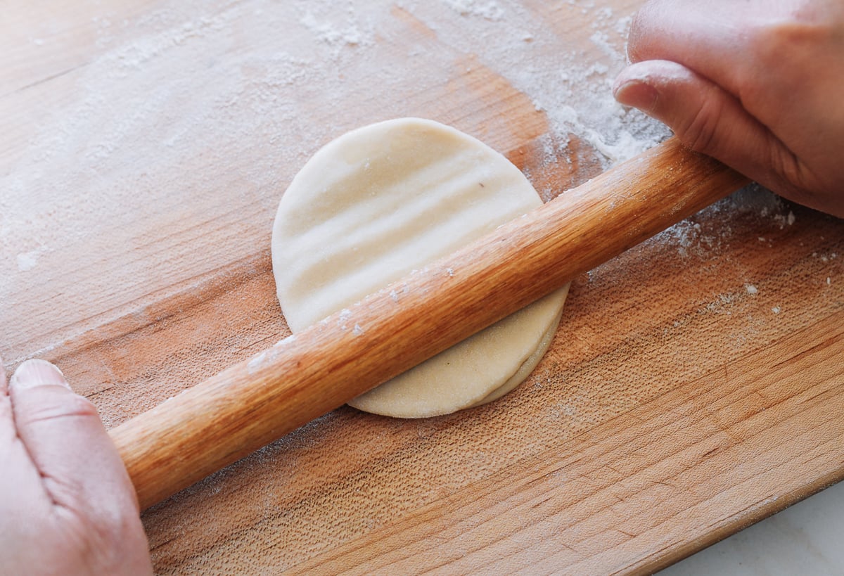 pressing dough circles with chinese rolling pin