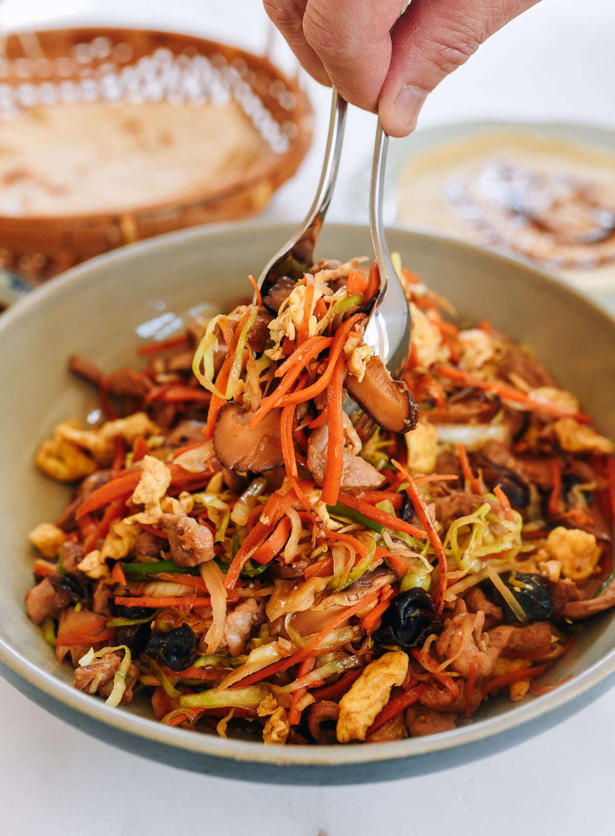 scooping moo shu pork filling with two spoons