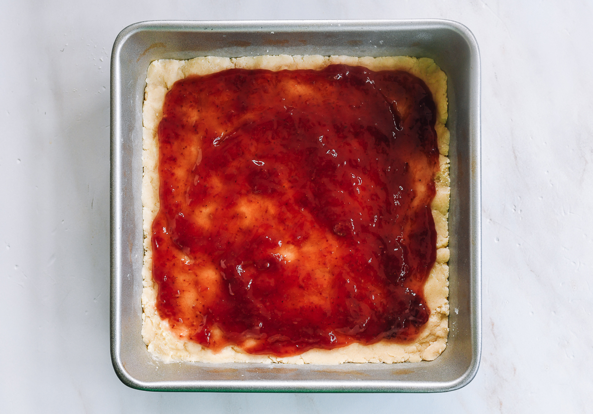 strawberry jam spread onto dough with border