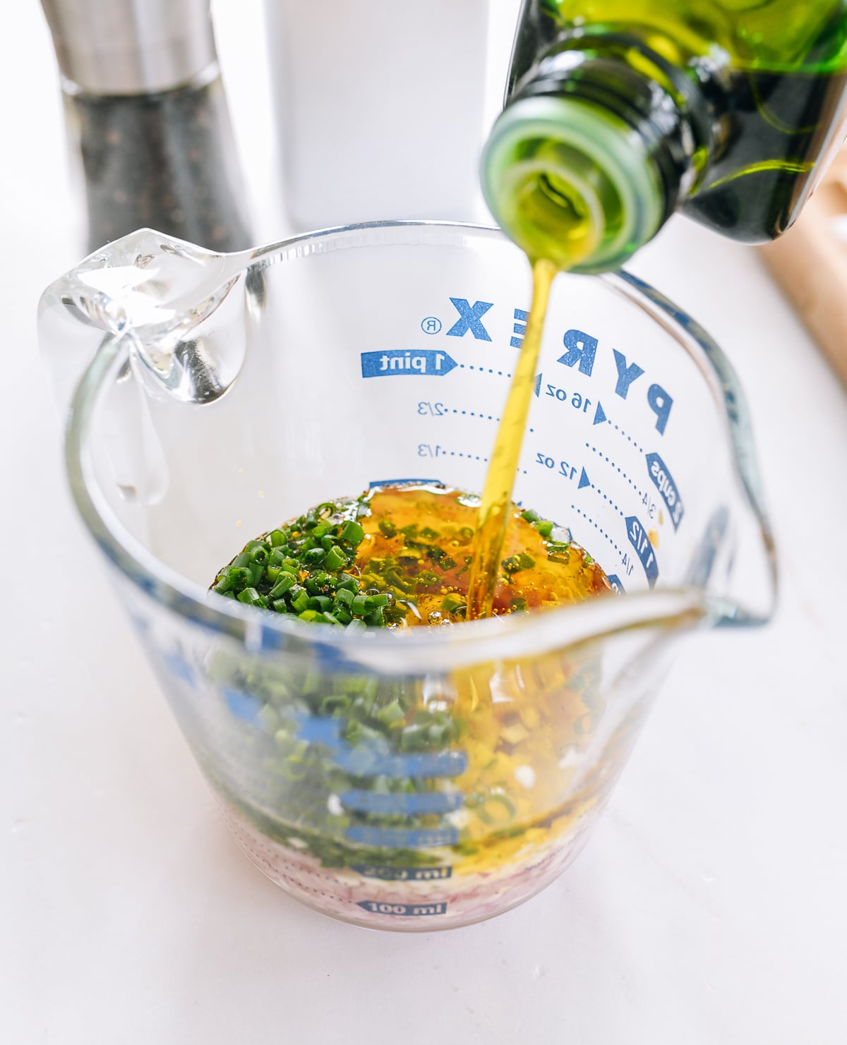 pouring olive oil into measuring cup