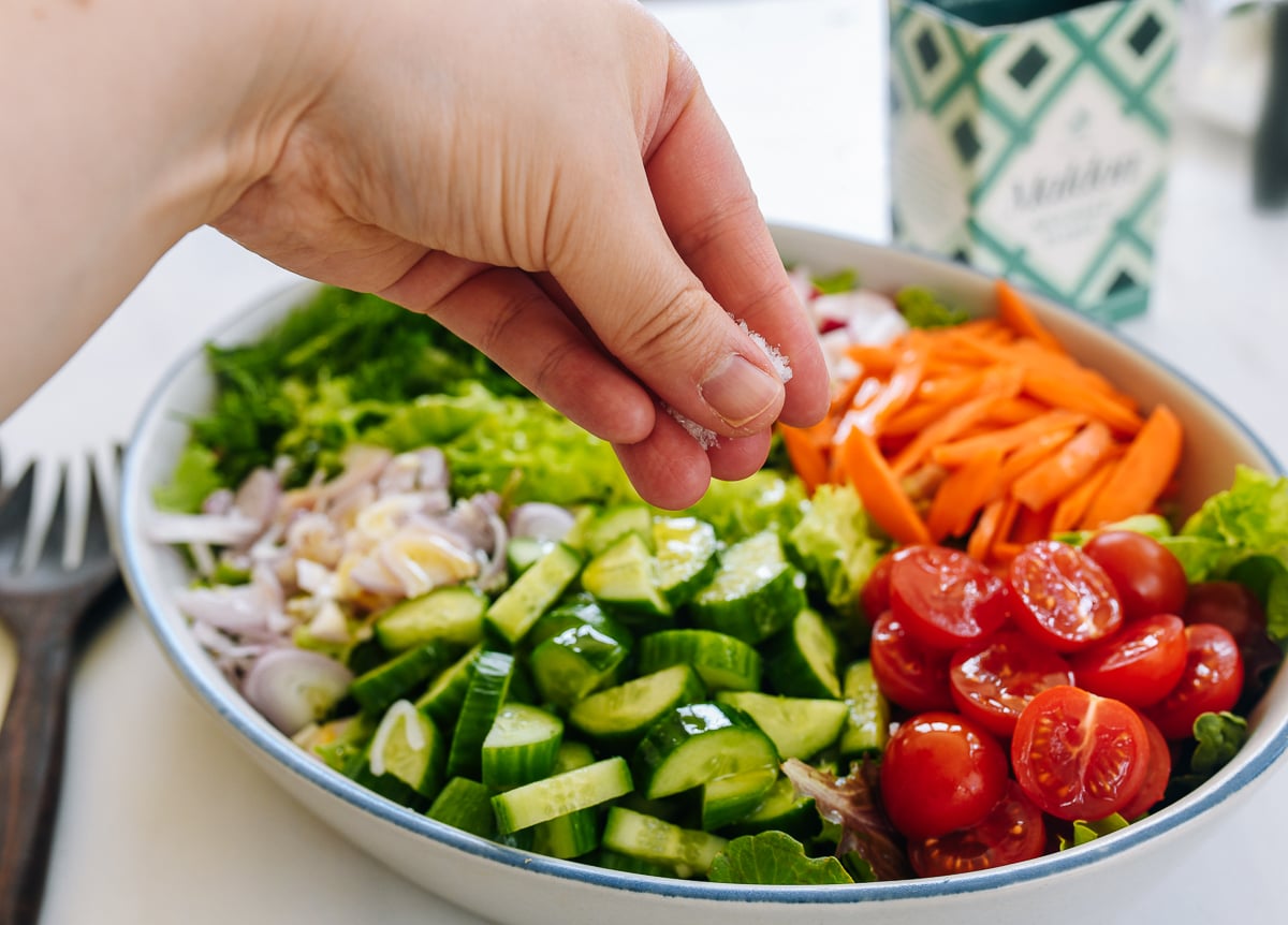 sprinkling salt over salad
