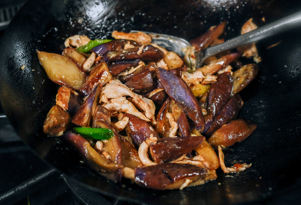 stir-frying eggplant and chicken in wok