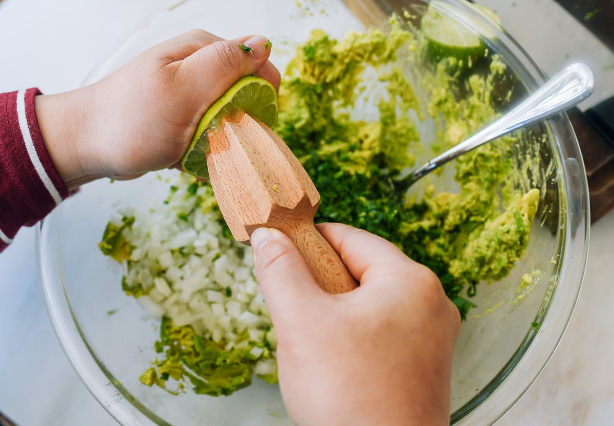squeezing lime juice over guacamole