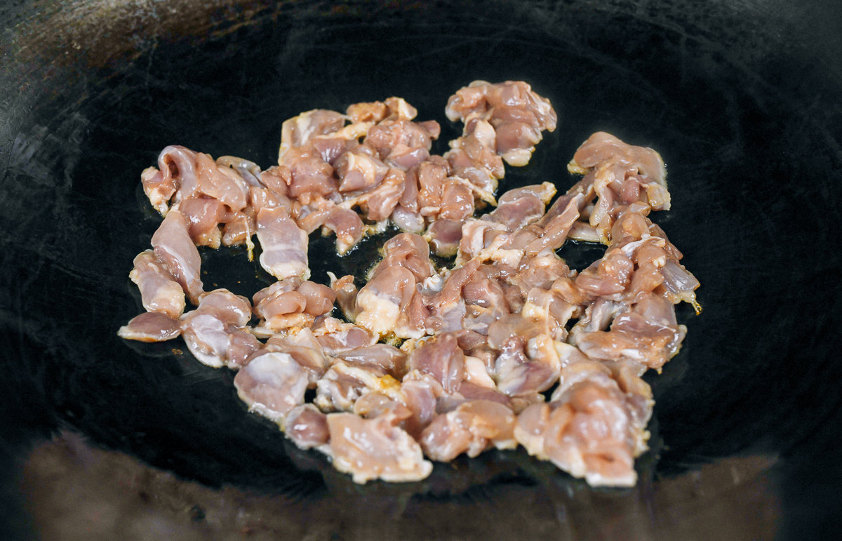 searing chicken pieces in wok