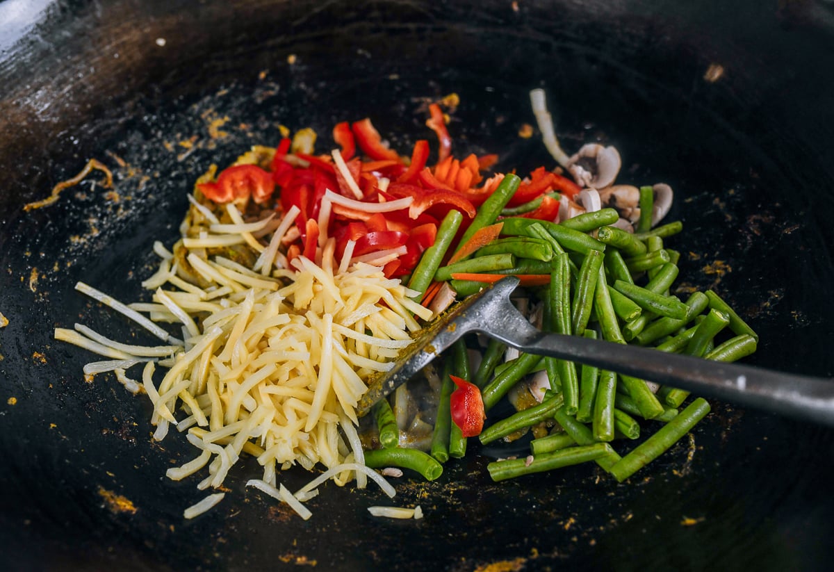 peppers, green beans, bamboo shoots added to wok with onions