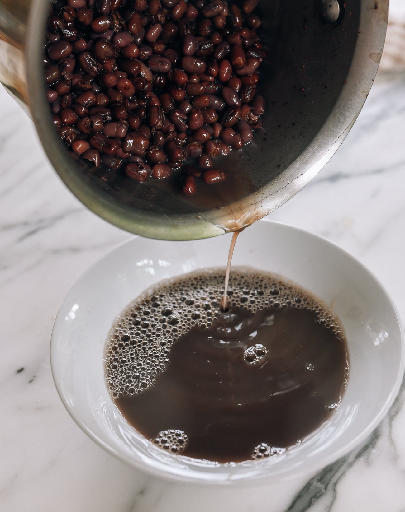 pouring off red bean cooking liquid