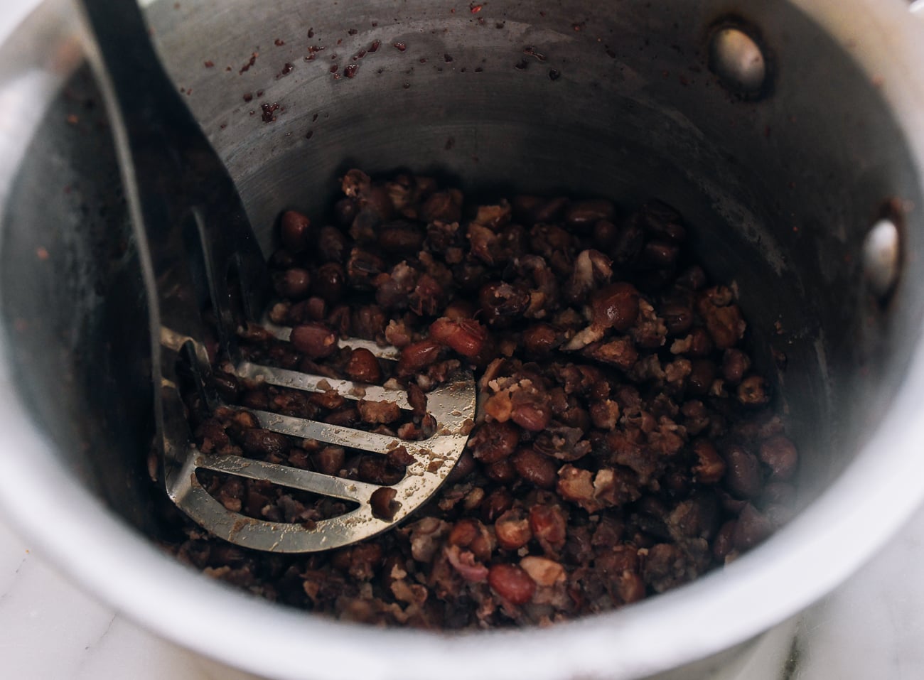 mashing red beans in pot