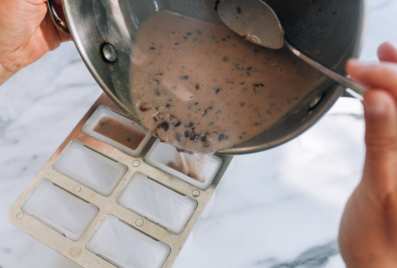 pouring red bean popsicle mixture into popsicle mold